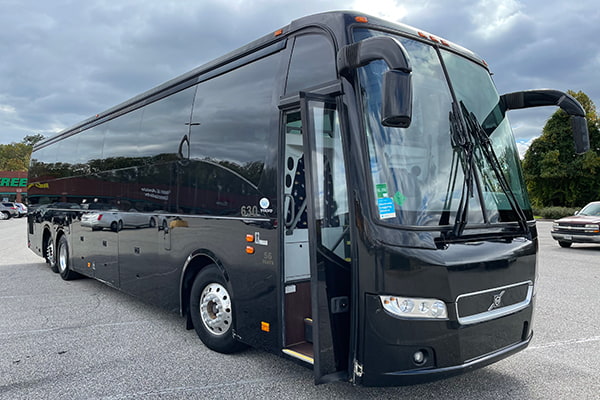 a black charter bus in a parking lot